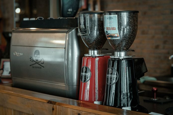 Costa Coffee-ს ლოგო და ყავის ჭიქა ბრიტანული სტილის კაფეში, თბილისის ფონზე